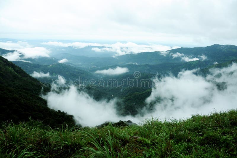 The high mountains tropical forest with clouds passing in India. royalty free stock photography