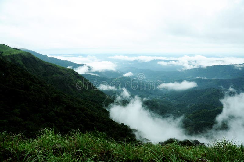 The high mountains tropical forest with clouds passing in India. royalty free stock image