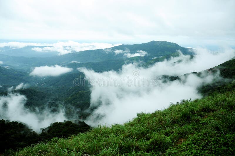 The high mountains tropical forest with clouds passing in India. royalty free stock photos