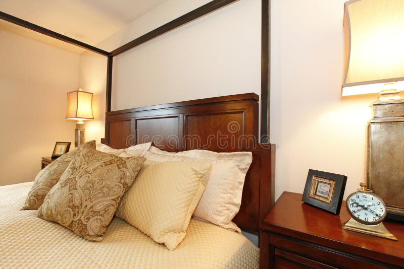 High Posts Bed with a Beautiful Beige Bedding and Nightstand. Cl Stock