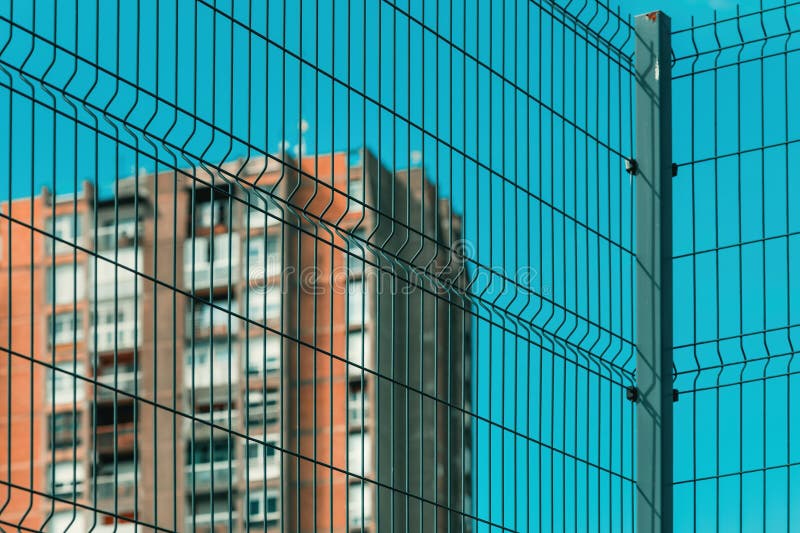 High rise architectural brutalism style apartment building behind metal fence royalty free stock images