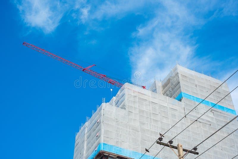 High rise Building Construction site with crane on blue sky background