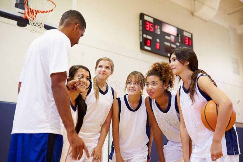 High School Basketball Team Having Team Talk With Coach