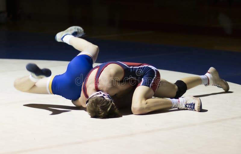 High school boys wrestling under a spotlight