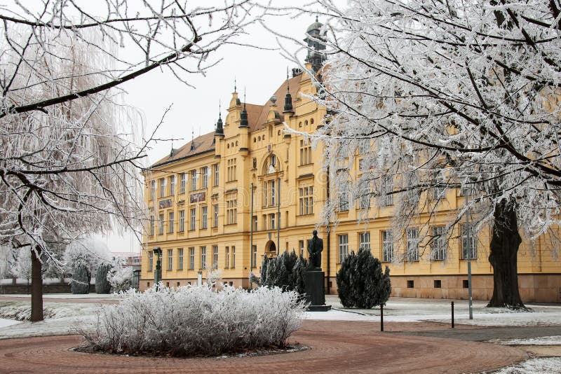 High school building amongst hoar frosted trees in cold winter day