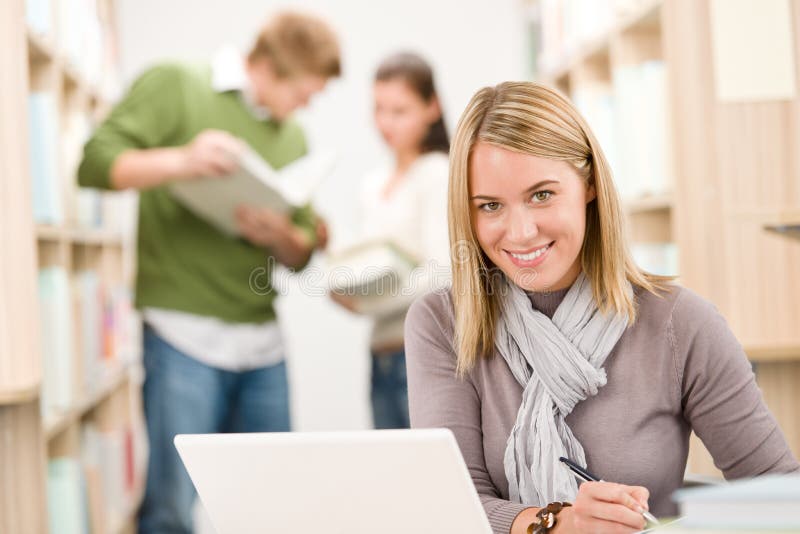 High school library - happy student with laptop