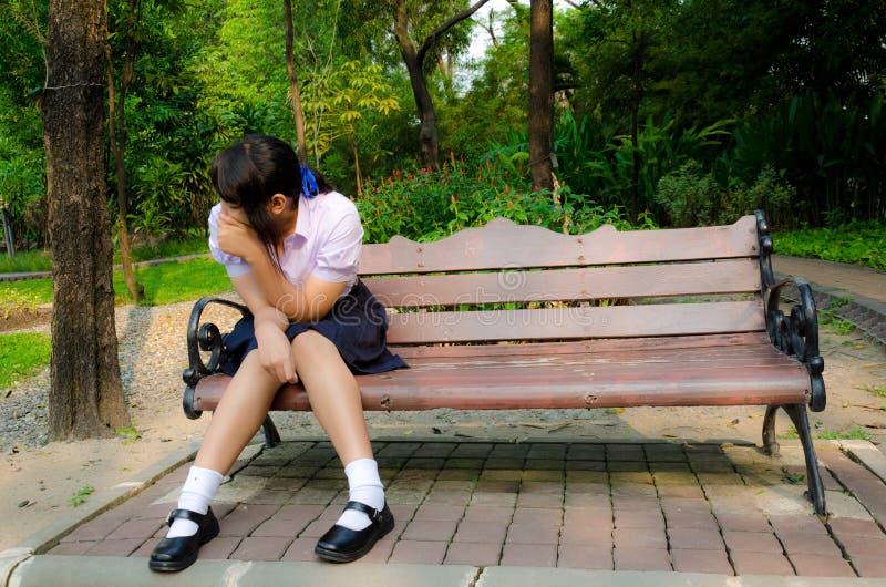 High-Schoolgirl crying alone on the bench