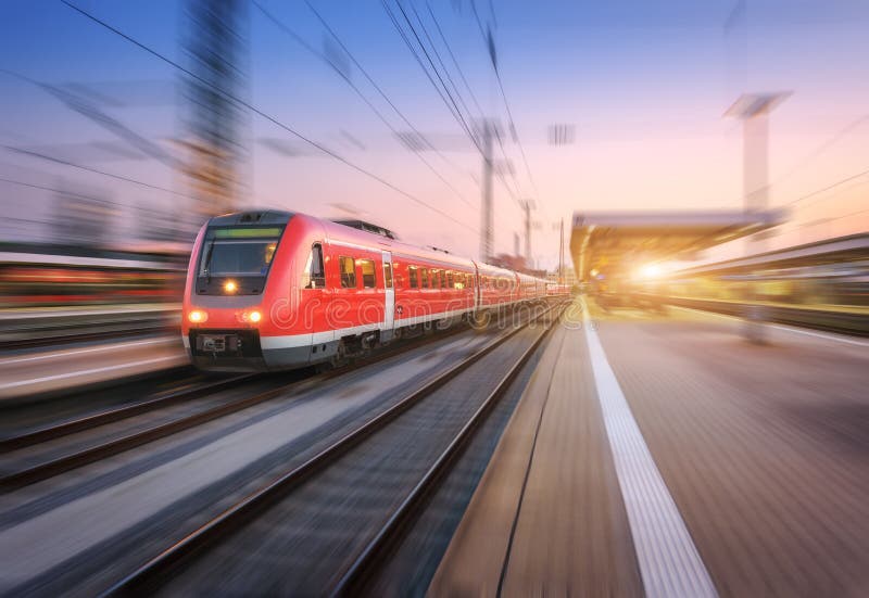 High speed red train with motion blur effect on the railway station