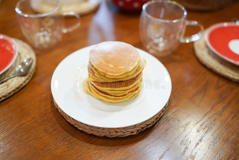 Stack of Pancakes on Plate on Wooden Table in the Kitchen . Breakfast