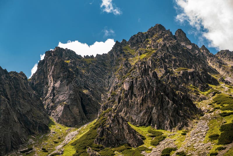 Vysoké Tatry vrchol s modrou oblohou a mraky na pozadí na Slovensku. Turistické stezky pro pěší turistiku v