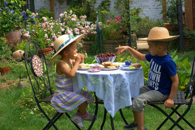 Dvě těší zvláštní piknik čaj v zahrada, oblečený příležitost.