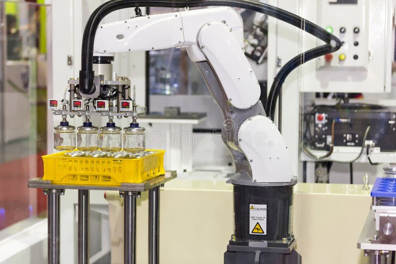 High technology of precision and accuracy industrial robot arm during working glass bottle lift from plastic box with automatic vacuum grip at factory.