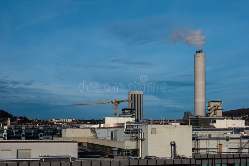 High vantage point view of industrial area of Zurich city Switzerland concrete smoking chimney in the background sunny day