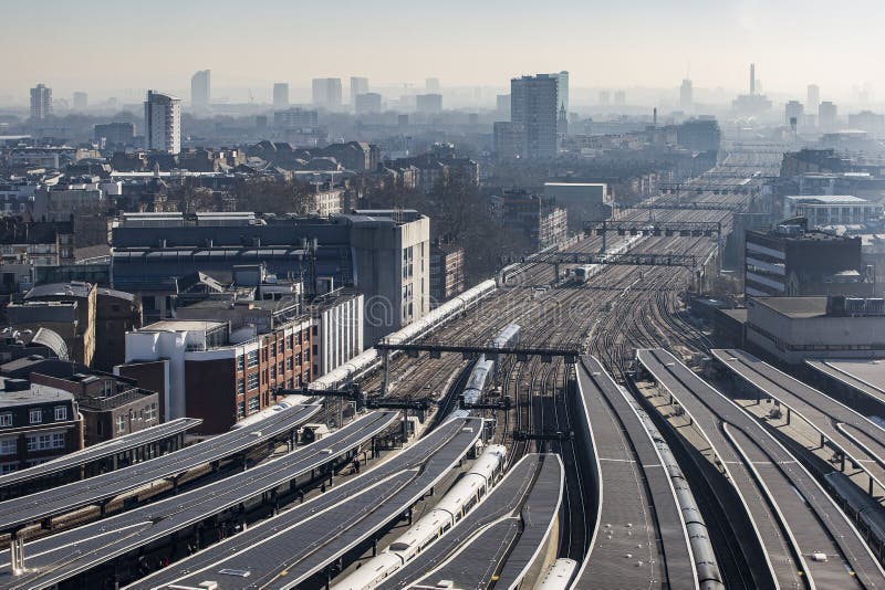 High view of London Bridge platform and rail tracks in winter sunlight fading to misty East London on the horizon. London, England United Kingdom. High view of London Bridge platform and rail tracks in winter sunlight fading to misty East London on the horizon. London, England United Kingdom