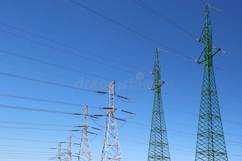 High voltage electric towers under blue sky