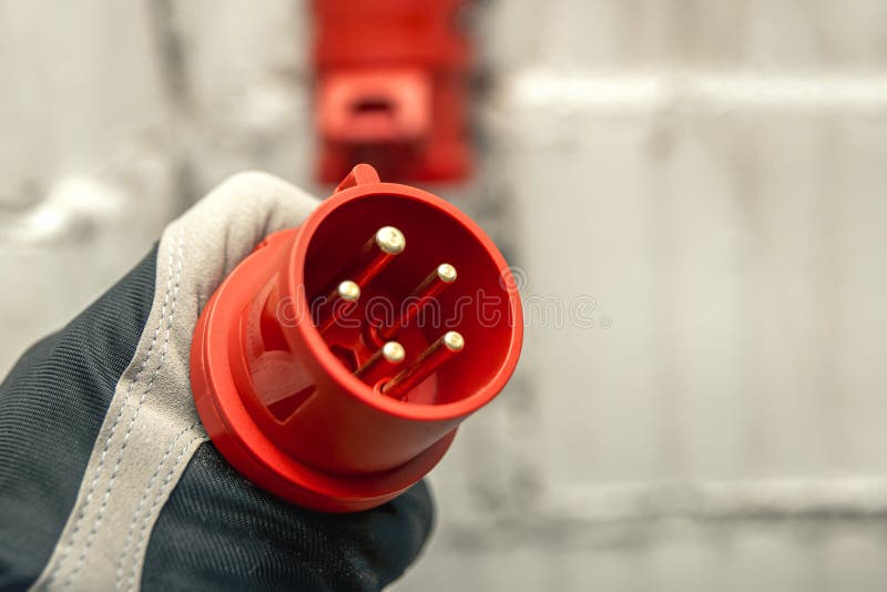 High Voltage Plug in Hand. Connecting a 380 Volt High Voltage, Three