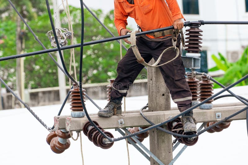 High voltage power line maintenance. Electrician at work. Electrical technician working on electric pole. High voltage power line