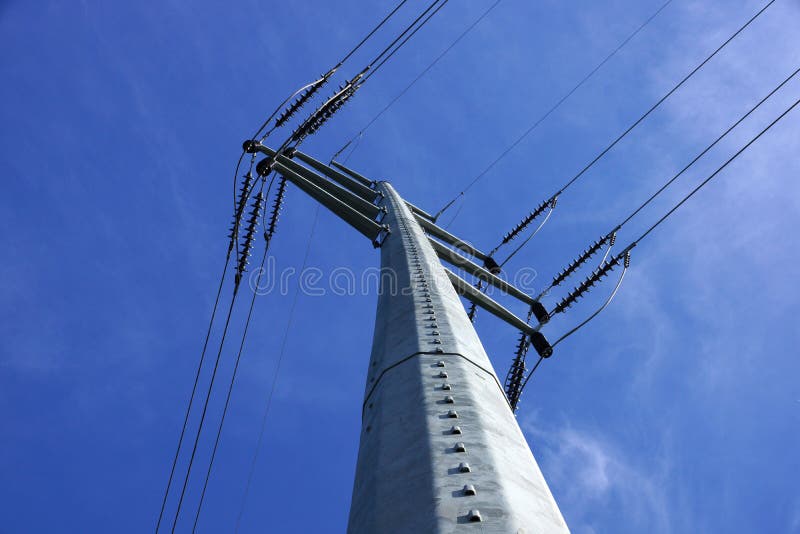 High Voltage Power Lines intersect at a large metal Utility pole