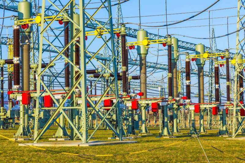 High voltage tower in rural landscape with blue sky