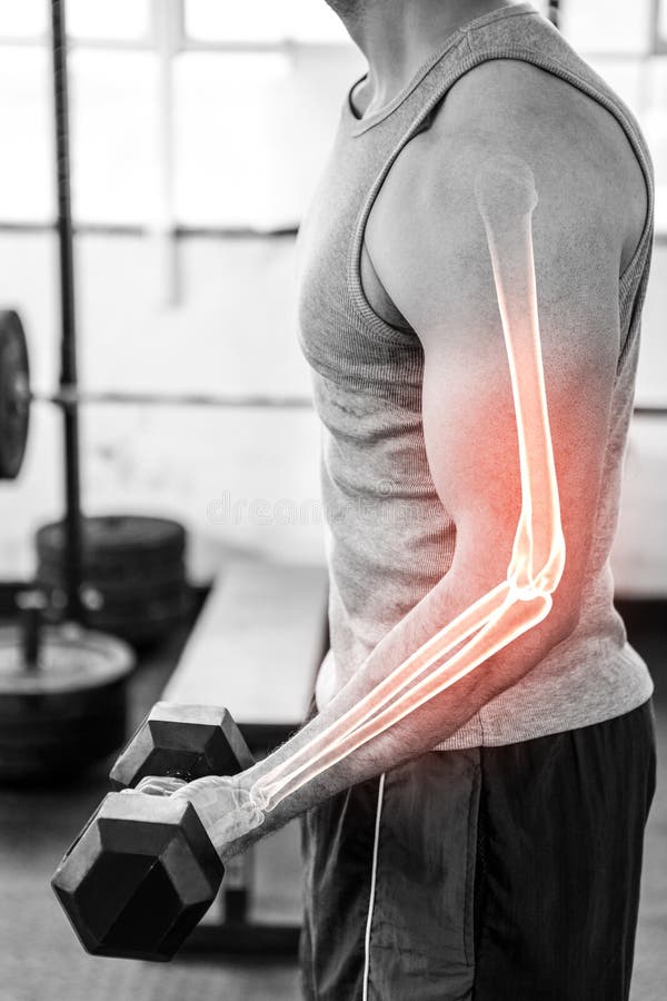 Highlighted Arm Of Strong Man Lifting Weights At Gym Stock Photo