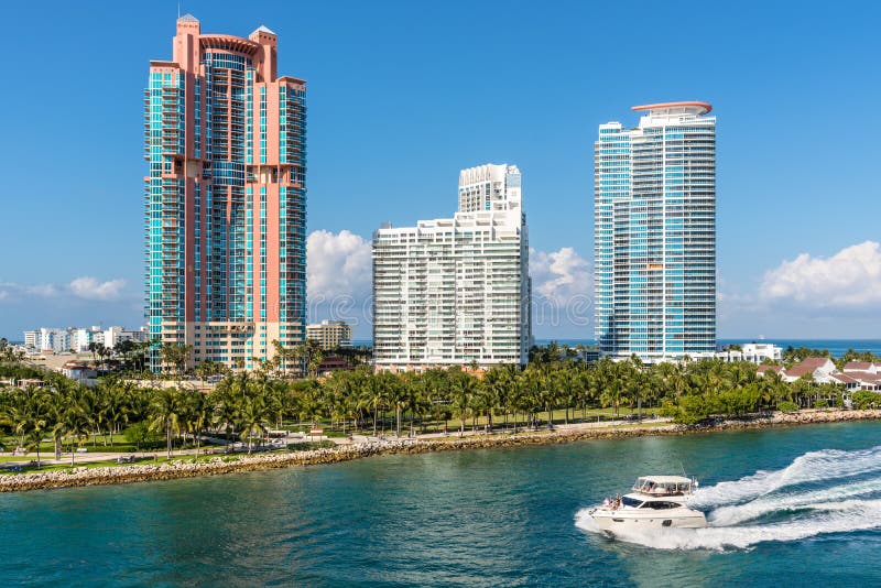 Miami, FL, United States - April 28, 2019: Luxury high-rise condominiums on the Florida Intra-Coastal Waterway in Miami Beach, Florida, USA. The South Pointe Park and motor boat in the foreground. Miami, FL, United States - April 28, 2019: Luxury high-rise condominiums on the Florida Intra-Coastal Waterway in Miami Beach, Florida, USA. The South Pointe Park and motor boat in the foreground