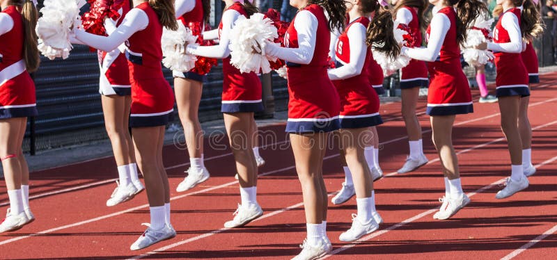 Highschool Cheerleadern, die während des Fußballspiels zujubeln lizenzfreies stockfoto Highschool Cheerleadern, die während des Fußballspiels zujubeln lizenzfreies stockfoto