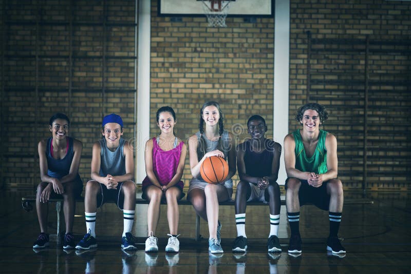 Highschool scherzt das Sitzen auf einer Bank im Basketballplatz stockfotos Highschool scherzt das Sitzen auf einer Bank im Basketballplatz stockfotos