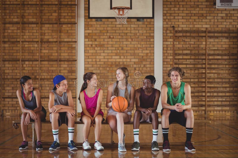 Highschool scherzt das Sitzen auf einer Bank im Basketballplatz stockbilder Highschool scherzt das Sitzen auf einer Bank im Basketballplatz stockbilder