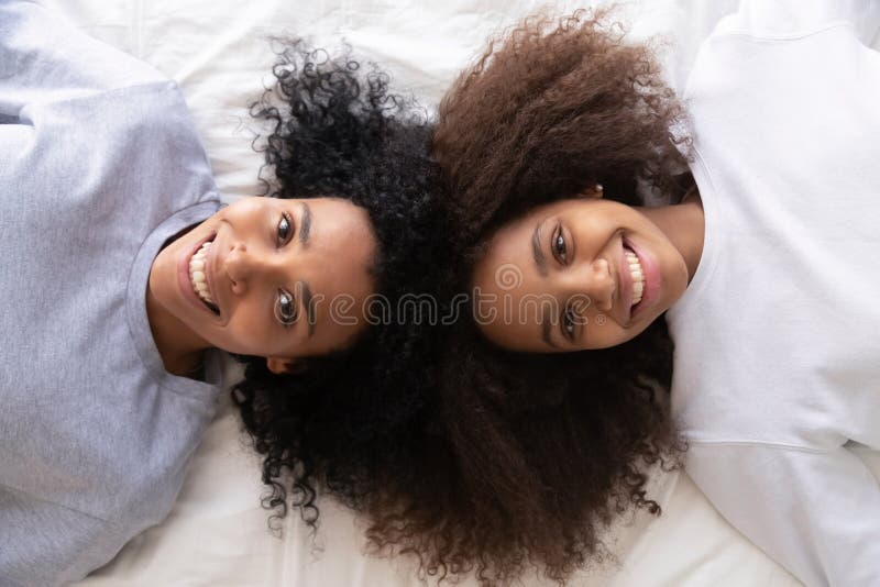 Hija africana y madre de la visión antedicha que mienten en cama fotografía de archivo Hija africana y madre de la visión antedicha que mienten en cama fotografía de archivo