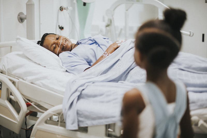 Hija que mira su sueño de la abuela en el hospital fotos de archivo Hija que mira su sueño de la abuela en el hospital fotos de archivo