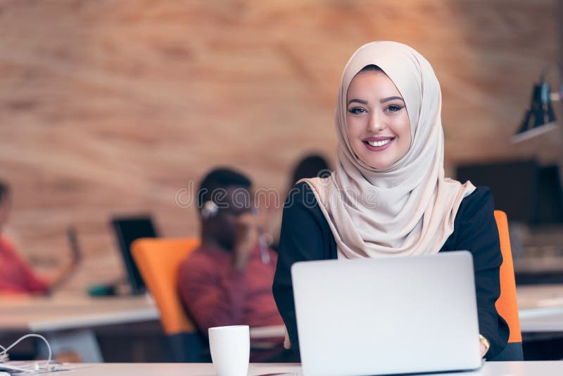 Hijab de port arabe de femme d'affaires, fonctionnant dans le bureau de démarrage