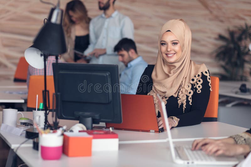 Hijab de port arabe de femme d'affaires, fonctionnant dans le bureau de démarrage photo stock Hijab de port arabe de femme d'affaires, fonctionnant dans le bureau de démarrage photo stock