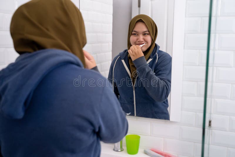 Hijab que lleva de la mujer cepillar sus dientes imagenes de archivo Hijab que lleva de la mujer cepillar sus dientes imagenes de archivo