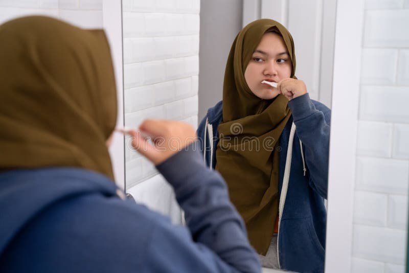 Hijab que lleva de la mujer cepillar sus dientes foto de archivo libre de regalías Hijab que lleva de la mujer cepillar sus dientes foto de archivo libre de regalías