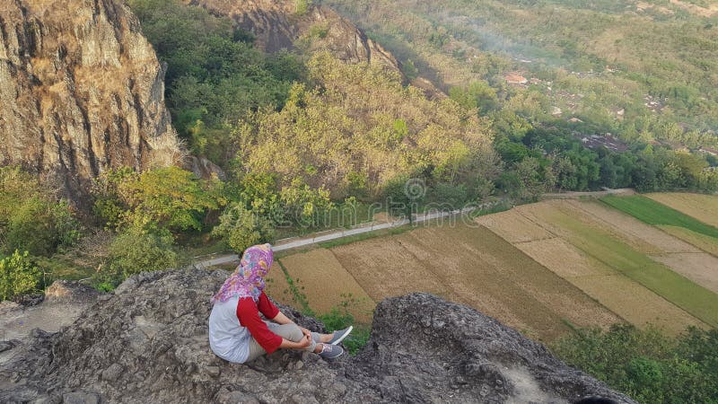 Hijab girl siting on peak of rock mountain royalty free stock images Hijab girl siting on peak of rock mountain royalty free stock images