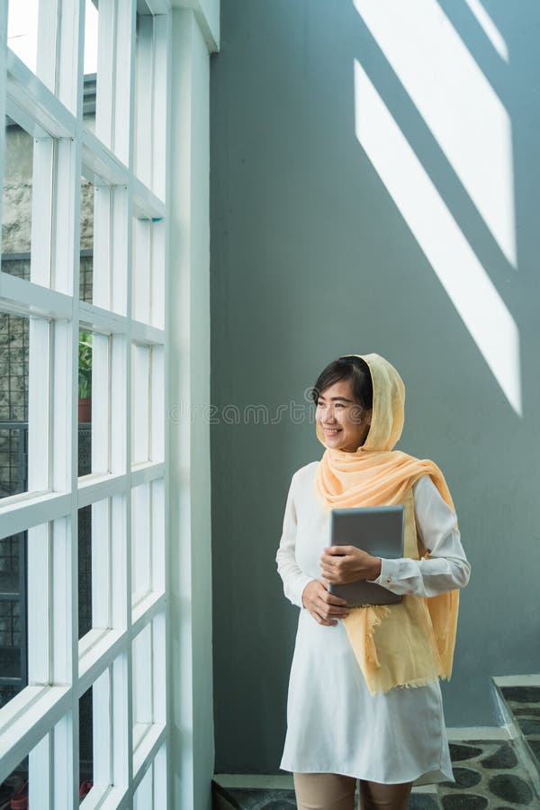 Hijab vestindo da mulher mu?ulmana usando o PC da tabuleta imagem de stock Hijab vestindo da mulher mu?ulmana usando o PC da tabuleta imagem de stock