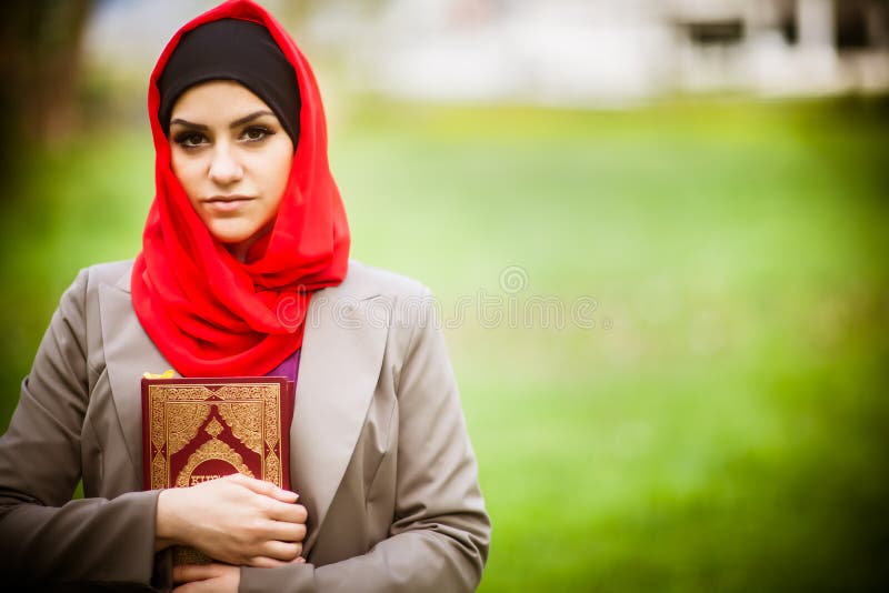 Hijab красивой мусульманской женщины нося и держать святую книгу Koran стоковые фотографии rf