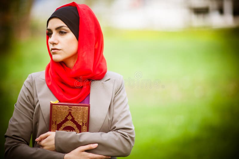 Hijab красивой мусульманской женщины нося и держать святую книгу Koran стоковое изображение rf