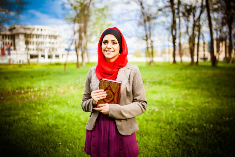 Hijab красивой мусульманской женщины нося и держать святую книгу Koran стоковые изображения