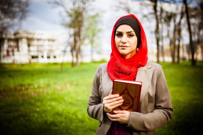 Hijab красивой мусульманской женщины нося и держать святую книгу Koran стоковое фото rf