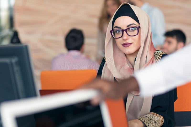 Hijab молодой арабской бизнес-леди нося, работая в ее startup офисе стоковые изображения