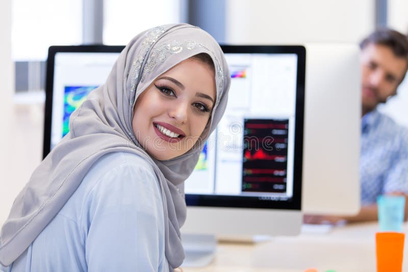 Hijab молодой арабской бизнес-леди нося, работая в ее запуске стоковое фото