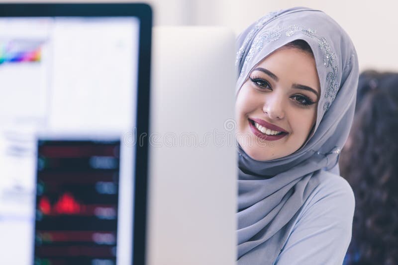 Hijab молодой арабской бизнес-леди нося, работая в ее запуске стоковые изображения