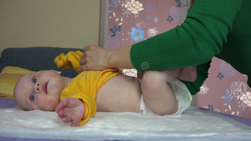 Hijo del bebé del vestido de la mujer con el paño amarillo del cuerpo del color 4K