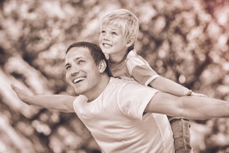 Hijo que juega con su padre en el parque durante el verano fotos de archivo libres de regalías Hijo que juega con su padre en el parque durante el verano fotos de archivo libres de regalías