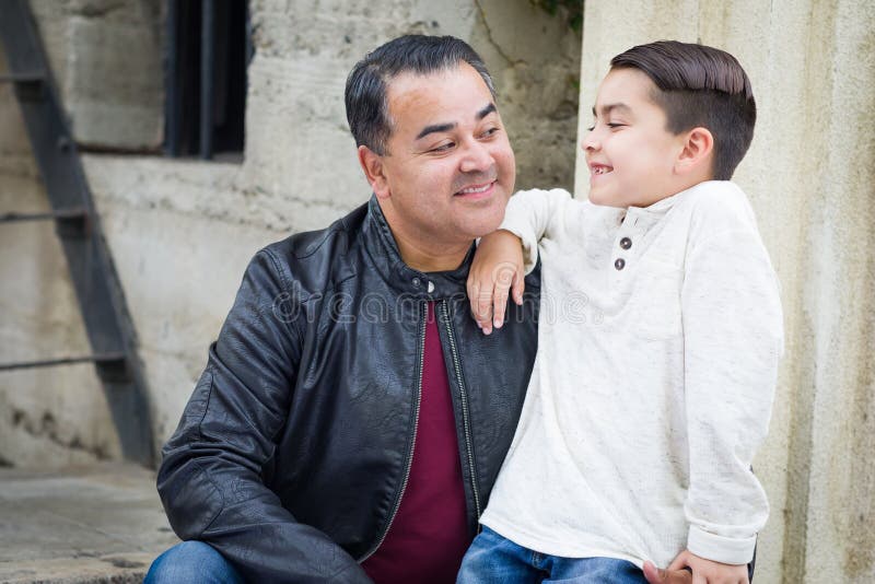 Hijo y padre caucásicos hispánicos Having de la raza mixta un Chatp foto de archivo Hijo y padre caucásicos hispánicos Having de la raza mixta un Chatp foto de archivo