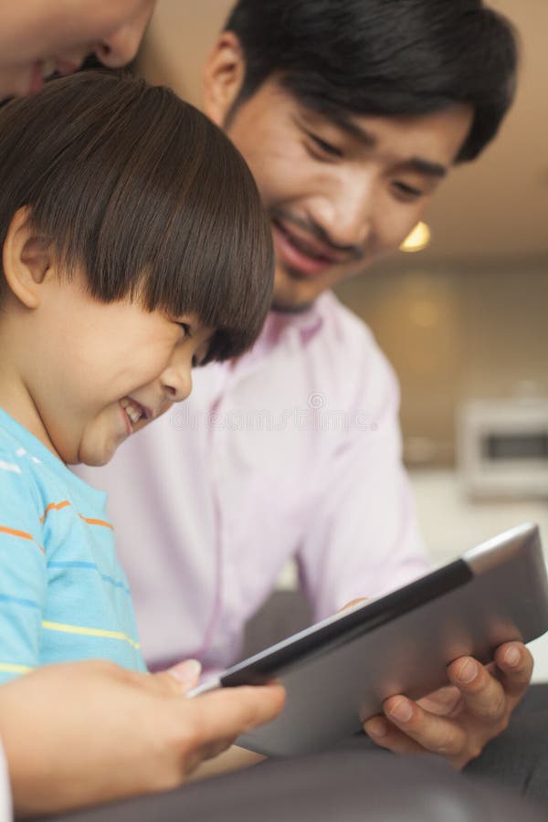 Hijo y sus padres que usan la tableta digital fotos de archivo libres de regalías