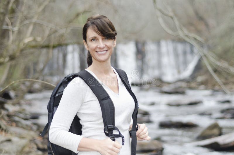 Pretty lady taking a hike by the river. Pretty lady taking a hike by the river