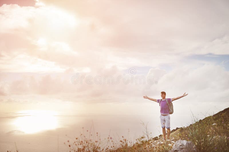 Hiker with arms wide open on top of a mountain - freedom conquest concept