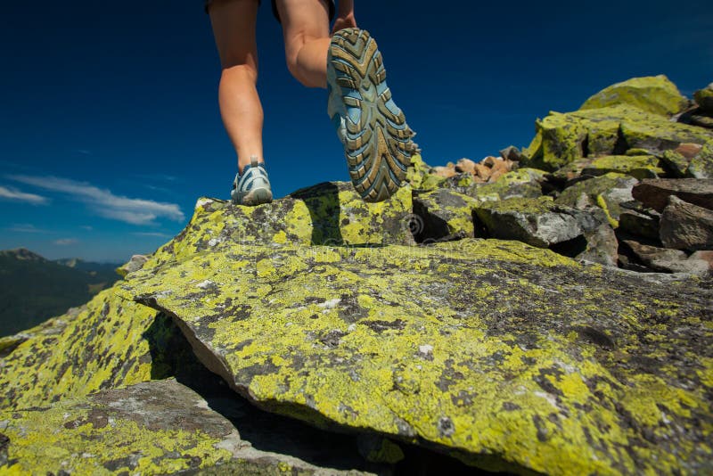 Hiker athlete is jumping over stones stock photos